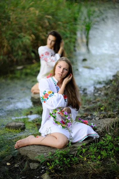 Zwei Mädchen in der ukrainischen Nationalkleidung mit Fließkränzen — Stockfoto