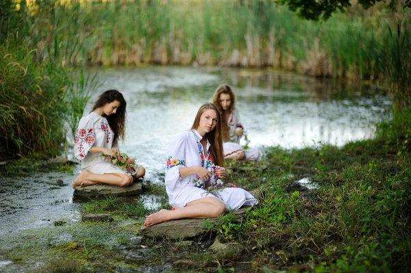 Trois filles dans les vêtements nationaux ukrainiens avec des couronnes de fl — Photo
