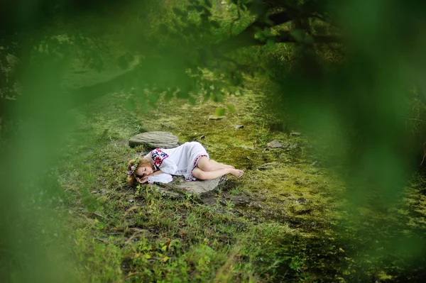 Ragazza ucraina in camicia e ghirlanda sulla testa dormire su un roc — Foto Stock
