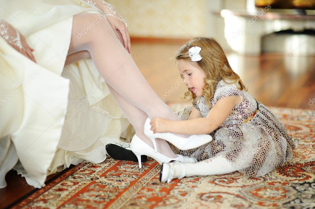 Little girl in a beautiful dress makes the bride wear white wedd