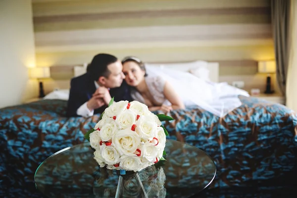 The bride and groom lying on the bed. In the foreground on the g — Stock Photo, Image