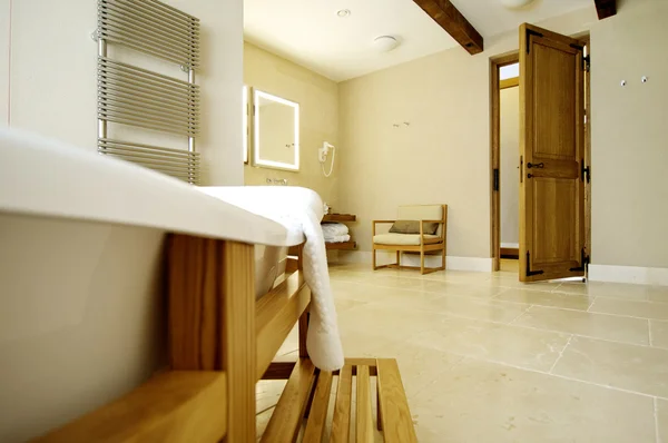 Hermoso baño blanco para una puerta abierta. Soportes de baño en una f de madera — Foto de Stock