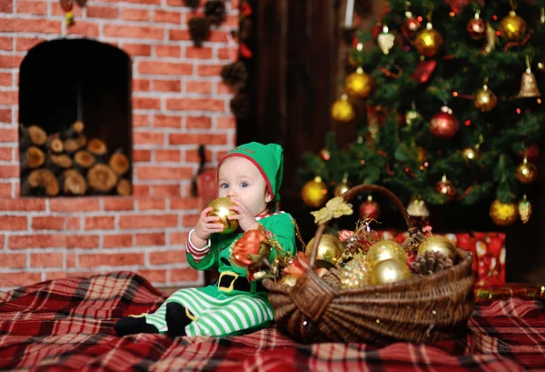 Niño vestido como un elfo sentado en un fondo a cuadros en el Chr —  Fotos de Stock