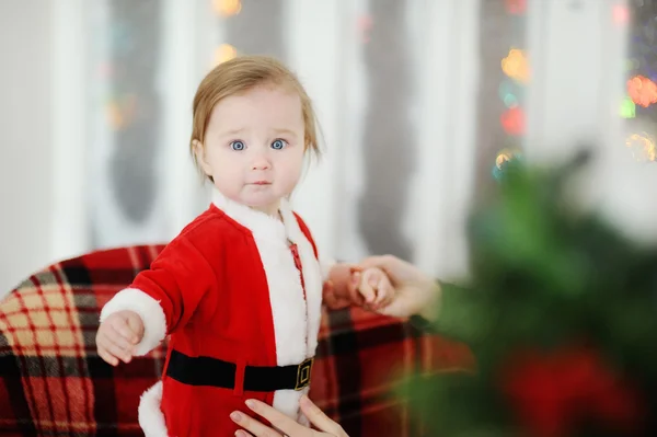 Child dressed as Santa Claus standing on a plaid chair — Stock Photo, Image