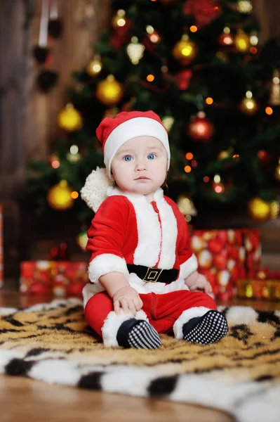 Niño vestido como Papá Noel sentado en una piel de tigre en la espalda —  Fotos de Stock