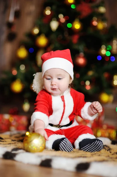Niño vestido como Papá Noel sentado en una piel de tigre en la espalda —  Fotos de Stock
