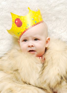 Child in a fur cape and crown on a white background clipart