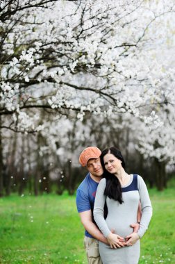 erkek ve kız çiçek açması kayısı arka plan üzerinde. Bir adam hugs