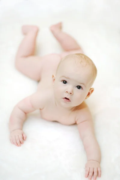 Kind liegt auf dem Bauch auf weißem Hintergrund — Stockfoto