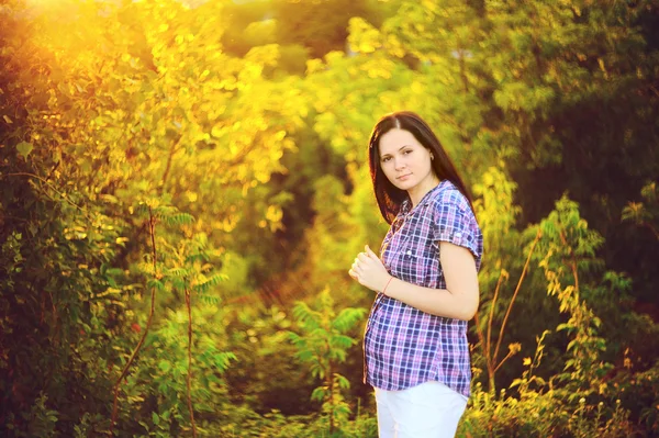 Вагітна дівчина на фоні листя — стокове фото