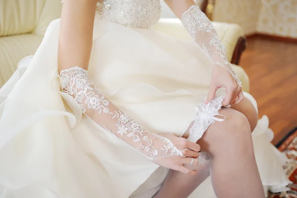 The bride wears a wedding garter on the leg — Stock Photo, Image