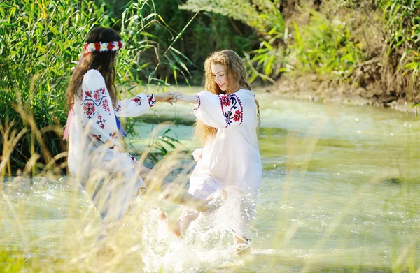 Két lány az ukrán nemzeti ruhát úszás a foly — Stock Fotó