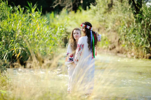 Due ragazze in camicie ucraine sono sullo sfondo del fiume — Foto Stock