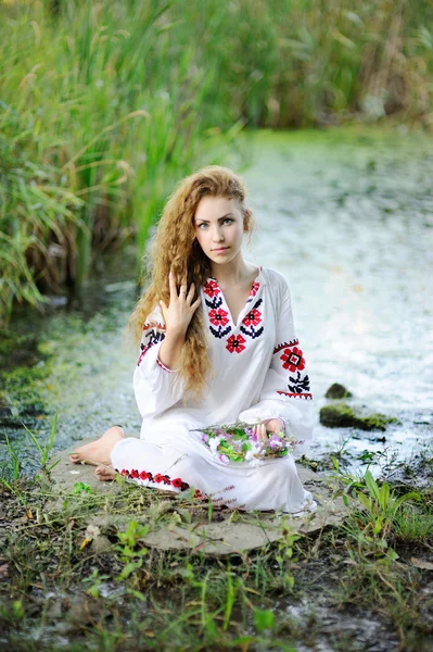 Chica en la ropa nacional de Ucrania con guirnaldas de flores o Fotos De Stock