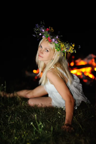 Ukrainisches Mädchen mit einem Blumenkranz auf dem Kopf gegen einen Ba — Stockfoto