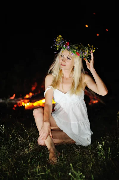 Oekraïense meisje met een krans van bloemen op haar hoofd tegen een ba — Stockfoto