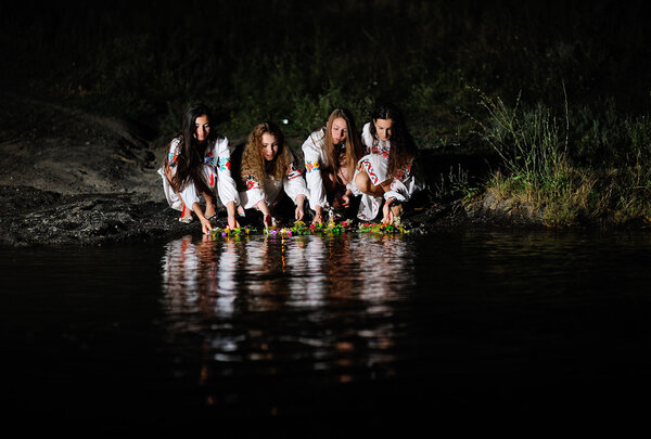 Ukrainian girls in shirts allowed wreaths of flowers on the wate