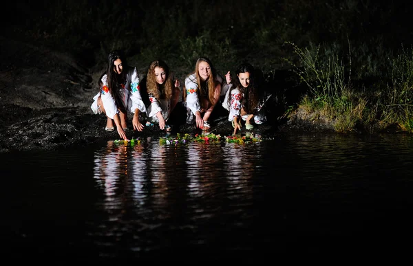 Filles ukrainiennes en chemises permises couronnes de fleurs sur la mer — Photo