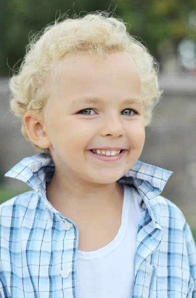 Curly-haired jongen in het shirt glimlachen — Stockfoto