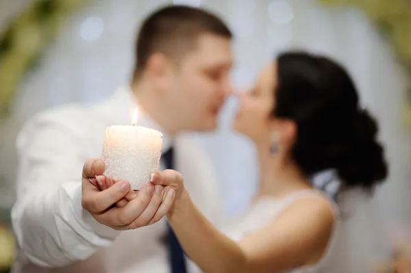 De bruid en bruidegom zijn bedrijf een mooie kaars — Stockfoto