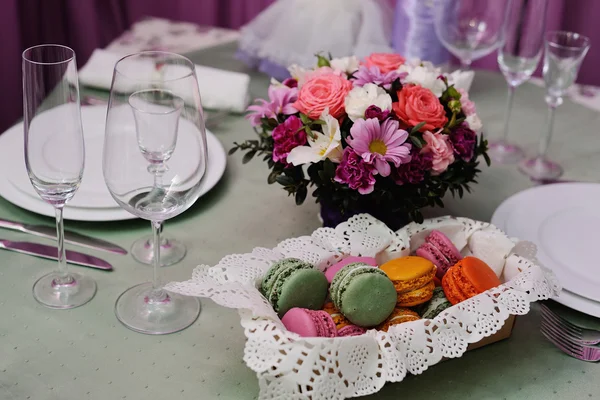 蛋白杏仁饼干和装饰桌子上的美丽的婚礼花束 — 图库照片