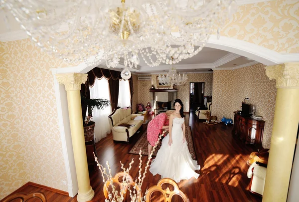 Anya segít a menyasszony, hogy egy esküvői ruhát viselni. reggel menyasszony — Stock Fotó