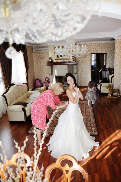 Mom helps the bride to wear a wedding dress. morning bride — Stock Photo, Image