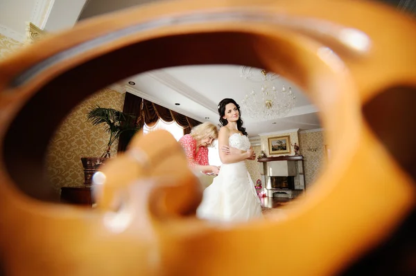 Anya segít a menyasszony, hogy egy esküvői ruhát viselni. reggel menyasszony — Stock Fotó