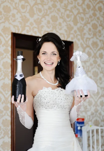 Bruid houdt twee flessen champagne als bruid en bruidegom — Stockfoto