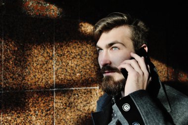 şık adam cep telefonuyla konuşan sakallı