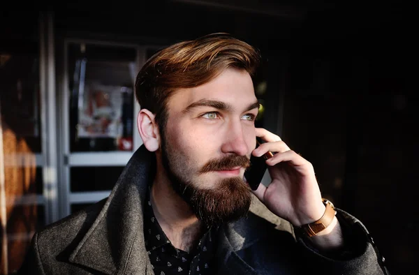 Κομψό άνδρα με μια γενειάδα μιλάμε για κινητό τηλέφωνο — Φωτογραφία Αρχείου