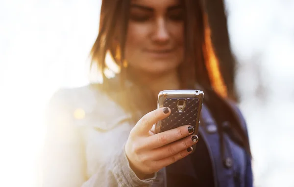 Menina marca mensagem sms no telefone móvel — Fotografia de Stock