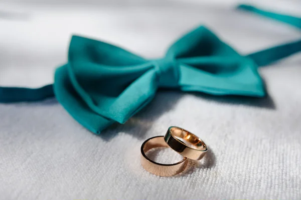 Wedding rings on a background of blue bow tie — Stock Photo, Image