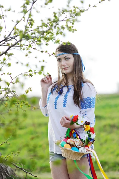 Славянская девушка в украинской рубашке с пасхальными корзинами в руках — стоковое фото