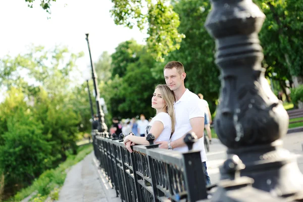 Guy embraces the girl on a background of green trees — Stock Photo, Image