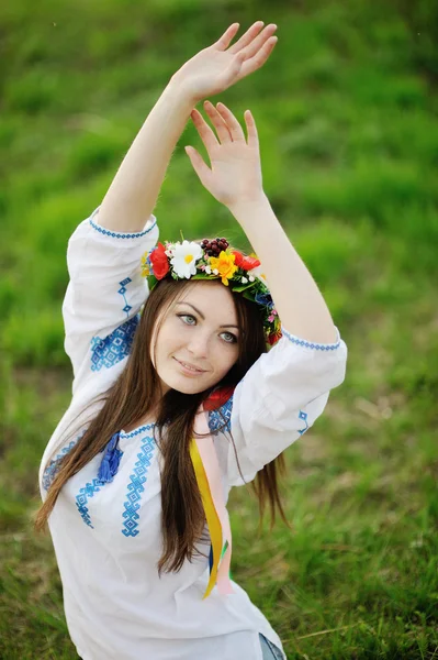 Ukrajinská dívka v košili a květinový věnec na její hlavu pullin — Stock fotografie