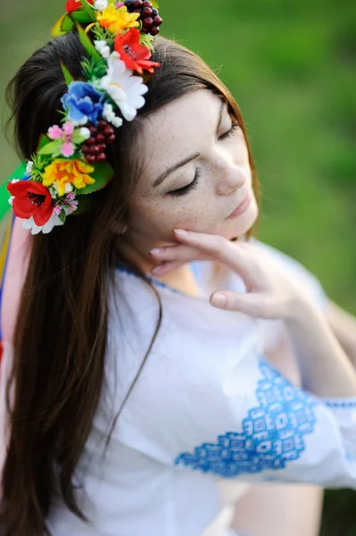 Meisje met sproeten op haar gezicht in een Oekraïense shirt en bloemen b — Stockfoto