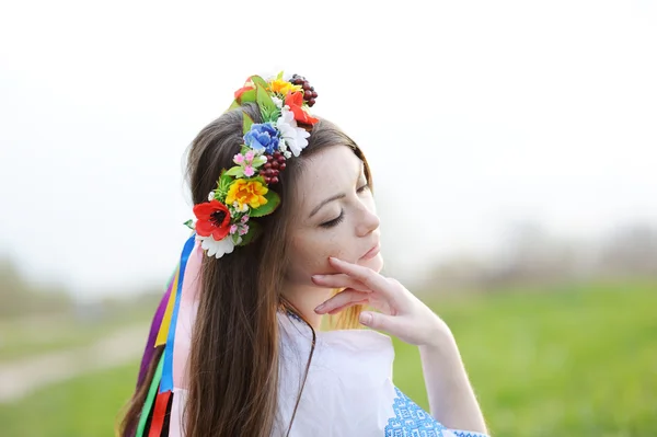 Chica ucraniana en una camisa y una corona de flores en su cabeza en una b Fotos De Stock Sin Royalties Gratis