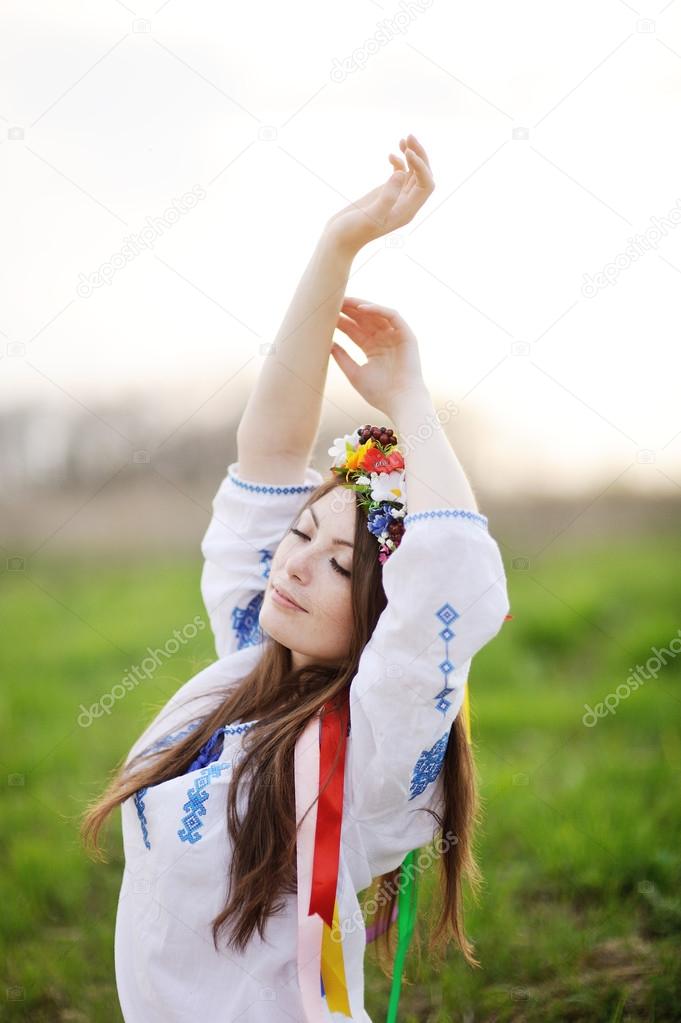 Ukrainian girl in a shirt and a floral wreath on her head pullin