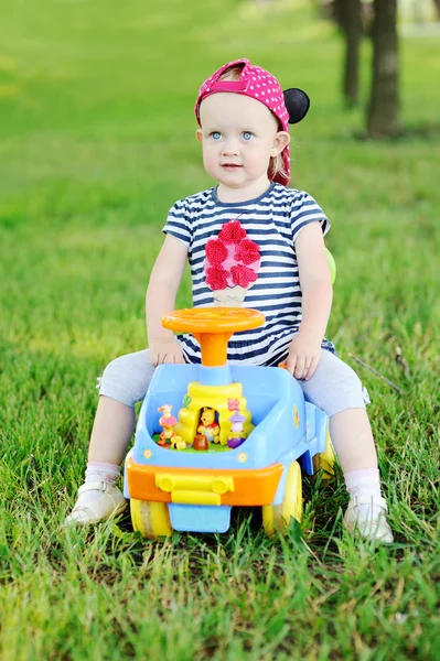 Kleines Mädchen auf einem Spielzeugauto — Stockfoto