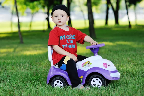 Маленький мальчик на игрушечной машине — стоковое фото