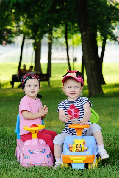 Две маленькие девочки в игрушечных машинах — стоковое фото