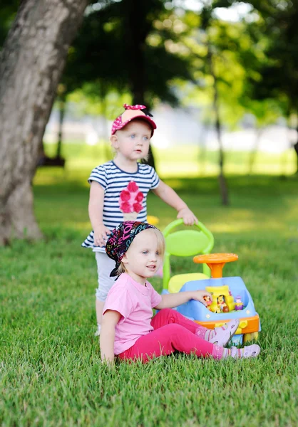Две маленькие девочки в игрушечных машинах — стоковое фото