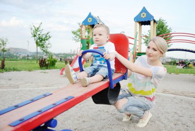 Mom and baby son play in the playground