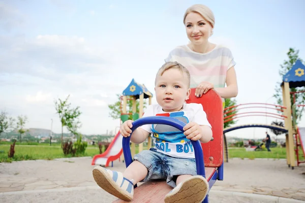 Mom and baby son play in the playground