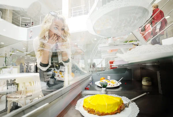 Menina com muita fome olhando para bolo saboroso — Fotografia de Stock