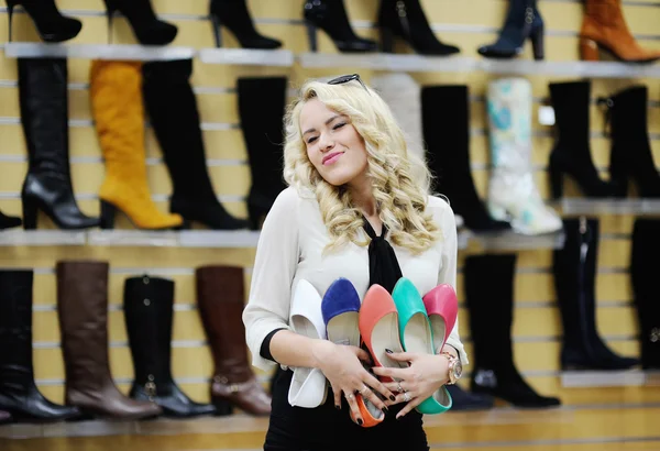 Schönes Mädchen wählt Schuhe. Blondes Mädchen misst die Stiefel im Laden — Stockfoto