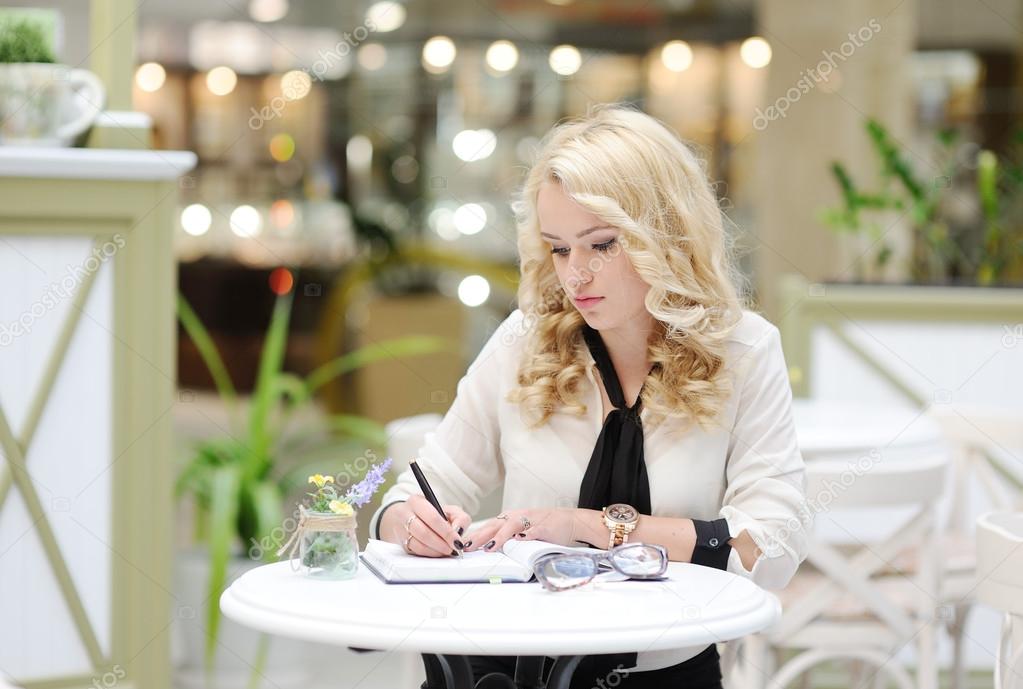 Beautiful girl writing in a notebook