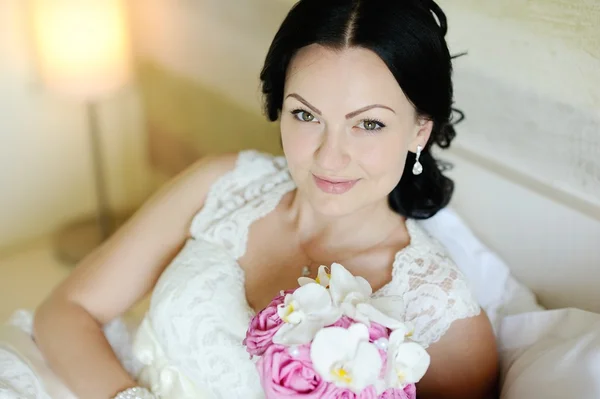 Beautiful bride with a wedding bouquet of orchids