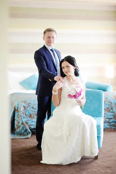 The bride and groom in the interior. Bride gently holding the ha — Stock Photo, Image